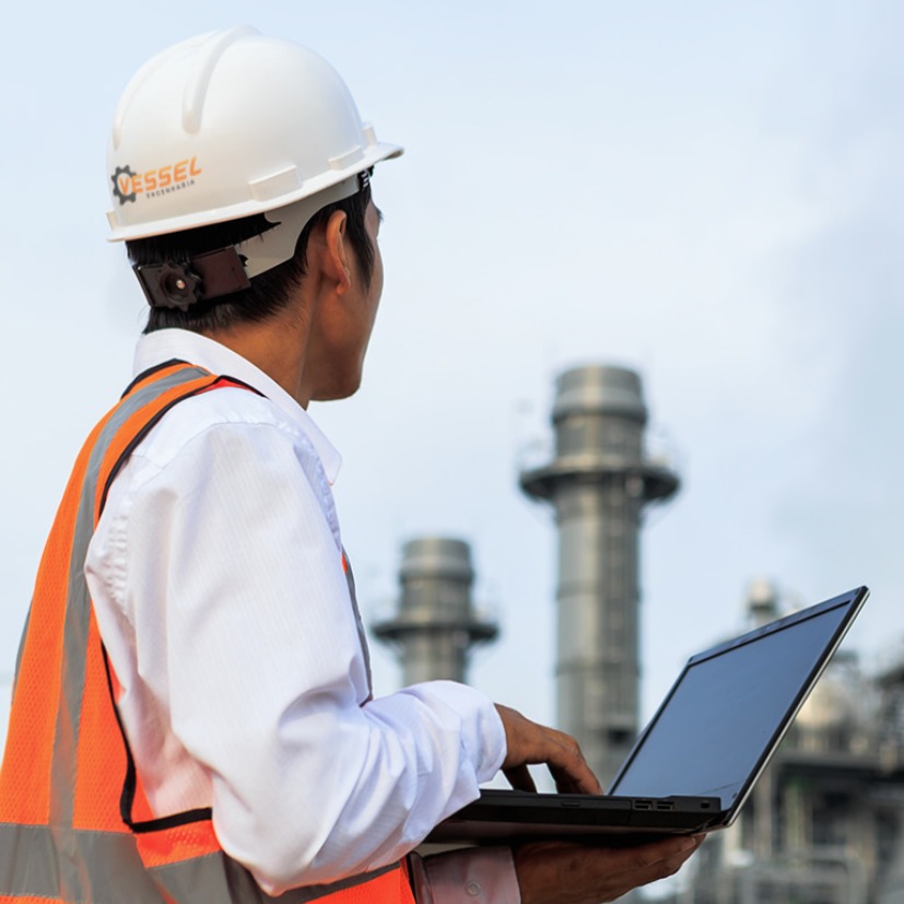 engenheiro eletrico de costas segurando laptop